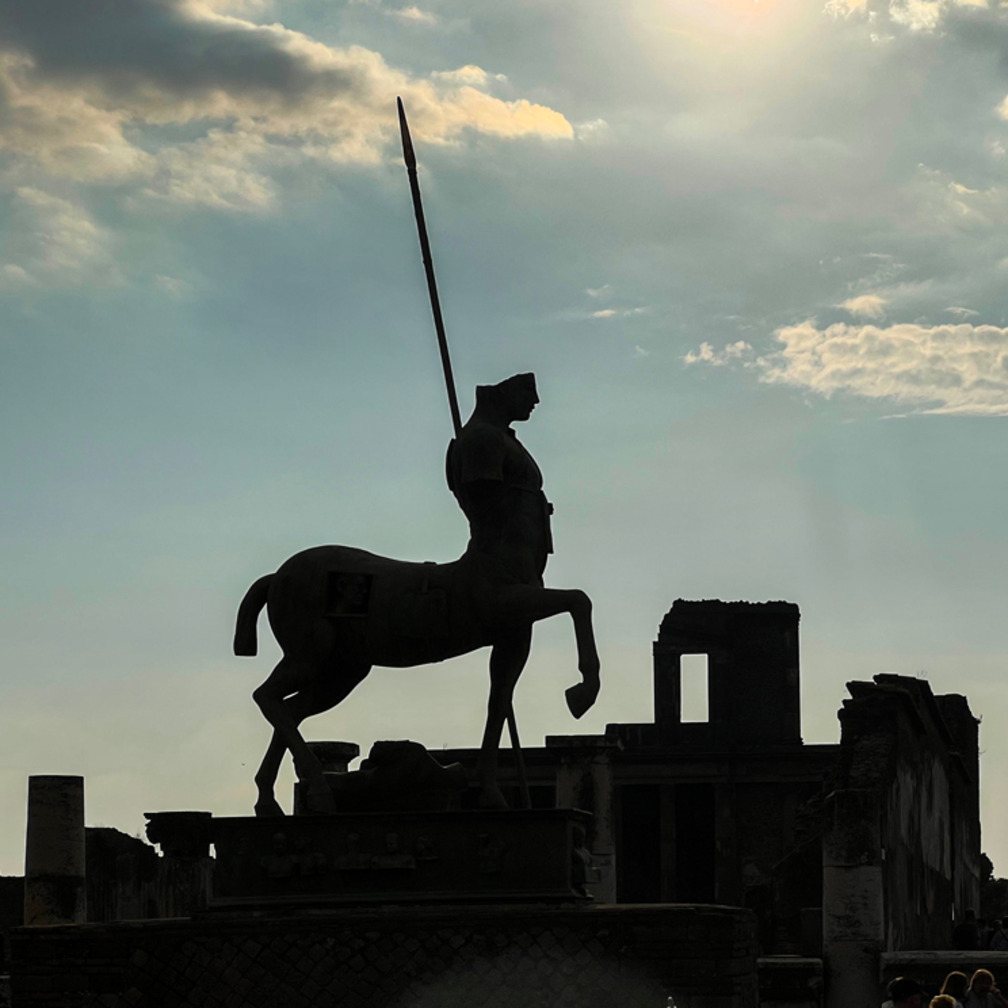 <p>龐貝，古羅馬城市，因毘諾火山於公元79年爆發而永久掩埋。今日的遺址展現出完整的街道、建築和藝術品，如羅馬劇場和弗拉維亞浴場。透過遺址，我們窺見當時居民的生活，也目睹了這場歷史的冰冷時刻。</p>
